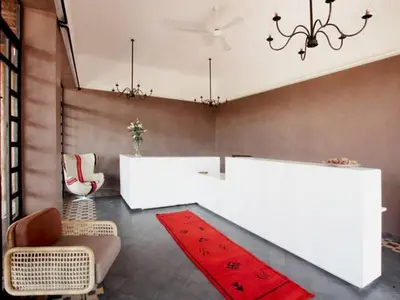 a living room with white tables and a red rug at Fellah Hotel in Marrakech