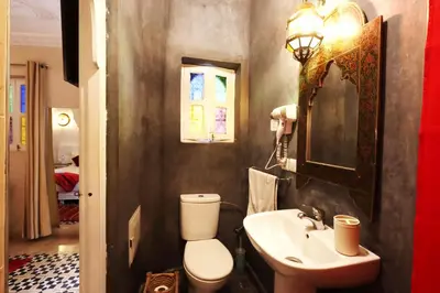 a bathroom with a sink and a toilet and a mirror at Riad Makech in Marrakech