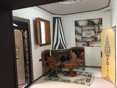 a room with chairs and a table and a mirror at Flashback House in Marrakech