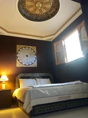 a bedroom with a bed and a ceiling with a window at Flashback House in Marrakech