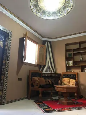 a living room with two chairs and a ceiling at Flashback House in Marrakech