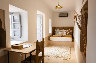a bedroom with a bed and a desk and a table at Riad El Jadide in Marrakech