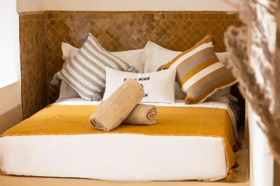 a bed with pillows and a stuffed animal on it at Riad El Jadide in Marrakech