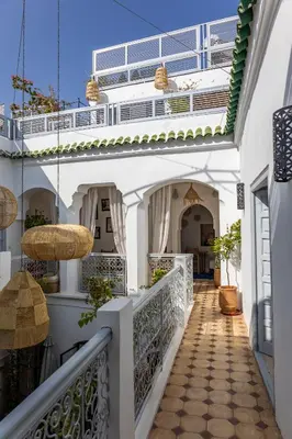 a hallway of a white building with potted plants at Riad El Jadide in Marrakech