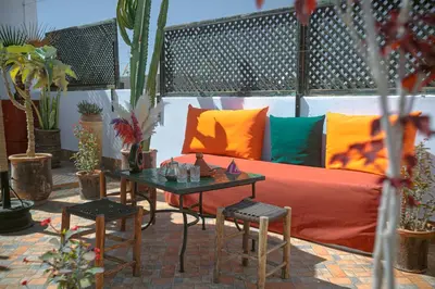 a couch and a table on a patio with plants at Riad Darino Marrakech Heritage in Marrakech