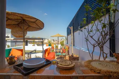 a patio with a table with an umbrella and chairs at Riad Darino Marrakech Heritage in Marrakech