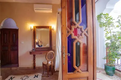 a door to a room with a mirror and a table at Riad Darino Marrakech Heritage in Marrakech