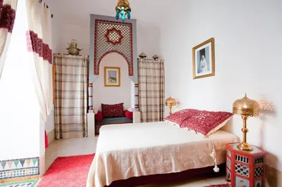 a bedroom with a bed and a red rug at Riad Zineb in Marrakech