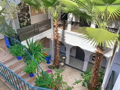 an indoor courtyard with palm trees and plants at Riad Rockech in Marrakech