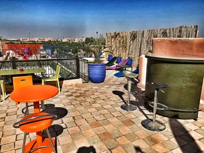 a patio with a grill and chairs and a table at Riad Rockech in Marrakech