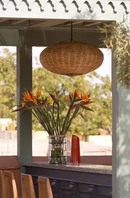 a vase with orange flowers on a table with a light at Riad Antara in Marrakech
