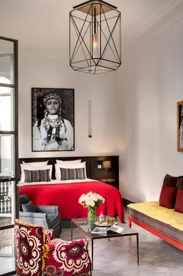 a living room with a red bed and a couch at Riad Antara in Marrakech
