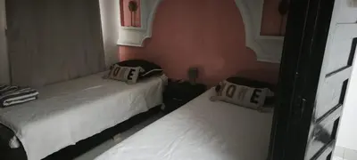 a room with two beds and a window with at Riad Naim in Marrakech