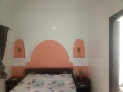 a bedroom with a bed with an orange headboard at Riad Naim in Marrakech