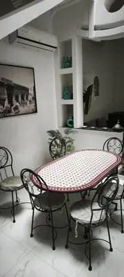 a table and chairs in a room with a table and chairs at Riad Naim in Marrakech