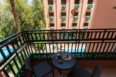 a table and chairs on a balcony with a building at Hotel Meriem Marrakech in Marrakech