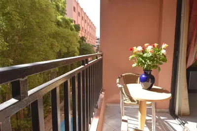 a vase of flowers sitting on a table on a balcony at Hotel Meriem Marrakech in Marrakech