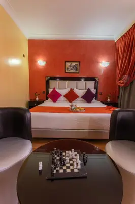 a bedroom with a bed with a chess board on a table at Hotel Meriem Marrakech in Marrakech