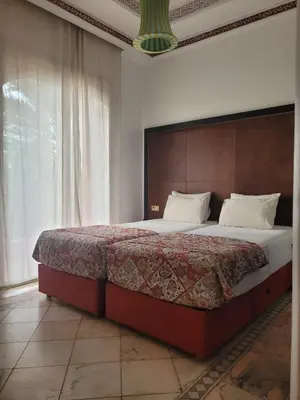 a bedroom with a large bed with a wooden headboard at Palmeraie village 2 , les jardins de la palmeraie 2 in Marrakech