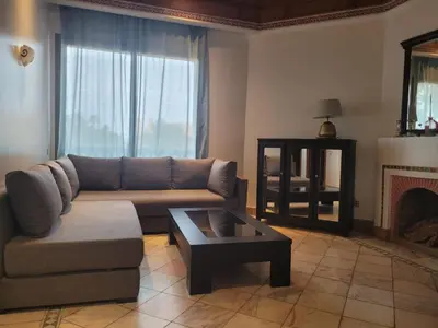 a living room with a couch and a fireplace at Palmeraie village 2 , les jardins de la palmeraie 2 in Marrakech