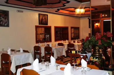 a restaurant with tables and chairs with white table cloth at Hotel Amalay in Marrakech