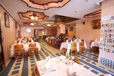 a restaurant with tables and chairs in a room at Hotel Amalay in Marrakech