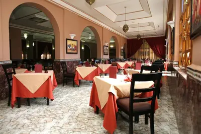 a restaurant with tables and chairs with red table cloth at Diwane Hotel & Spa Marrakech in Marrakech