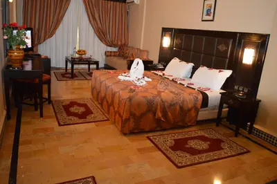a hotel room with a bed and a living room at Diwane Hotel & Spa Marrakech in Marrakech