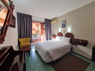 a hotel room with a bed and a balcony at Hotel Tachfine in Marrakech