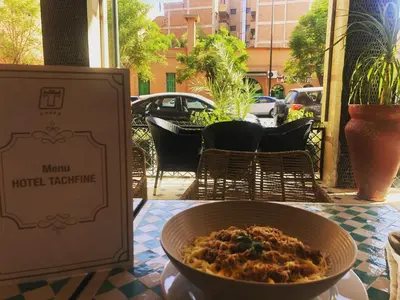 a bowl of food on a table next to a box at Hotel Tachfine in Marrakech