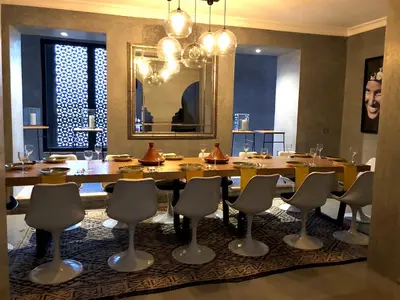 a dining room with a large wooden table and chairs at Palais Souad in Marrakech