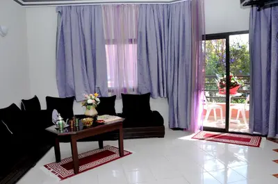 a living room with purple curtains and a table at Residence Hotel Assounfou in Marrakech