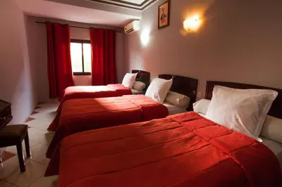 a hotel room with two beds and a couch at Residence Hotel Assounfou in Marrakech