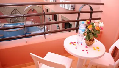 a table with a vase of flowers on a balcony at Residence Hotel Assounfou in Marrakech