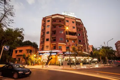 a car parked in front of a tall building at Residence Hotel Assounfou in Marrakech