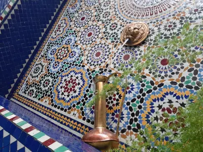 a tiled wall with a fountain on top of it at Riad La Porte des 5 Jardins in Marrakech