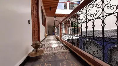 a hallway with a wrought iron fence and a tile floor at Riad La Porte des 5 Jardins in Marrakech