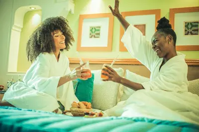 two women sitting in bed with their hands in the air at Jaal Riad Resort Adults Only in Marrakech