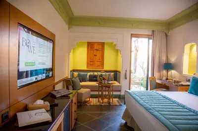 a bedroom with a bed and a living room at Jaal Riad Resort Adults Only in Marrakech