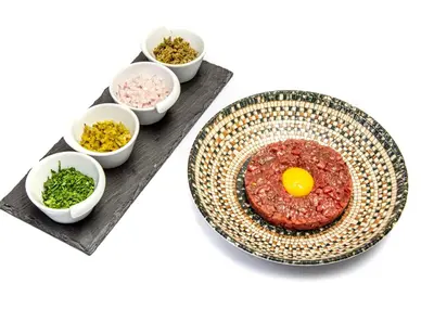 a plate with an egg on a table with bowls of ingredients at Jaal Riad Resort Adults Only in Marrakech