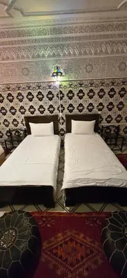two beds in a room with a wall at Riad Raffaa in Marrakech