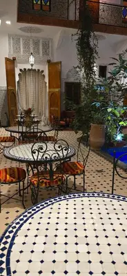 a room with tables and chairs on a tiled floor at Riad Raffaa in Marrakech