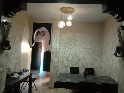 a dining room with a table and a chandelier at Magnifique Appt Atlas Golf Resort Marrakech in Marrakech
