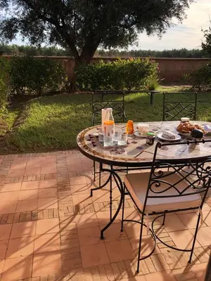 a table and chairs sitting on a patio at Magnifique Appt Atlas Golf Resort Marrakech in Marrakech