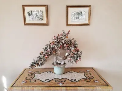 a plant in a vase on a table with two pictures at Oranger Family House Marrakech City Center in Marrakech