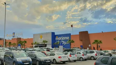 a parking lot full of cars in front of a building at Oranger Family House Marrakech City Center in Marrakech