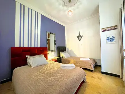 a hotel room with two beds and a mirror at Oranger Family House Marrakech City Center in Marrakech