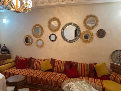 a living room with a couch and mirrors on the wall at Riad SARSAR airport in Marrakech