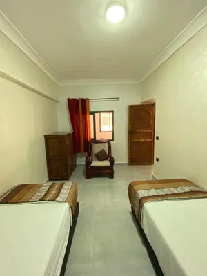 a room with two beds and a chair in it at Villa des Roses Privée in Marrakech