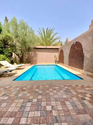 a swimming pool in the backyard of a house at Villa des Roses Privée in Marrakech